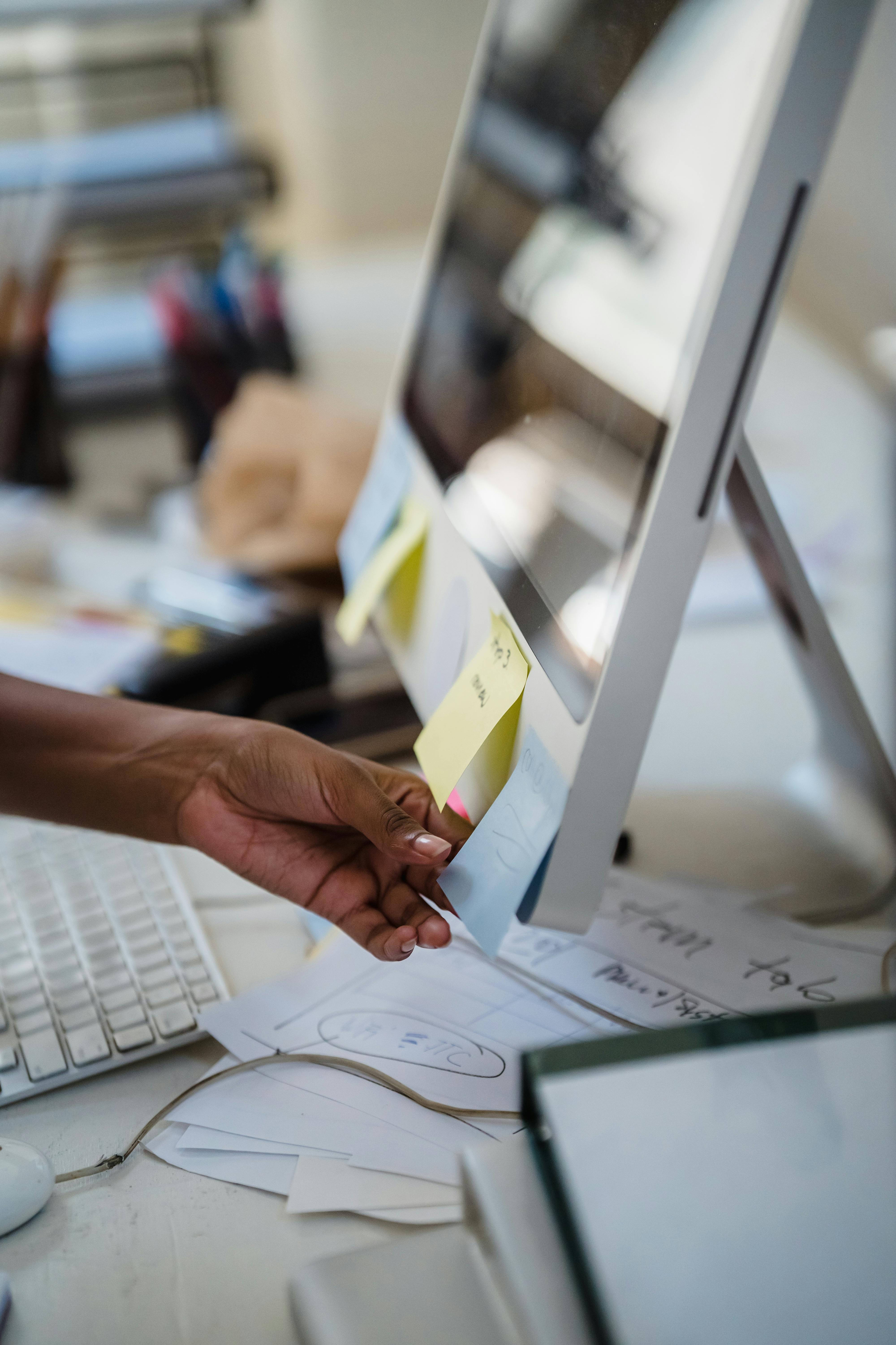 Hands placing sticky notes on a workspace